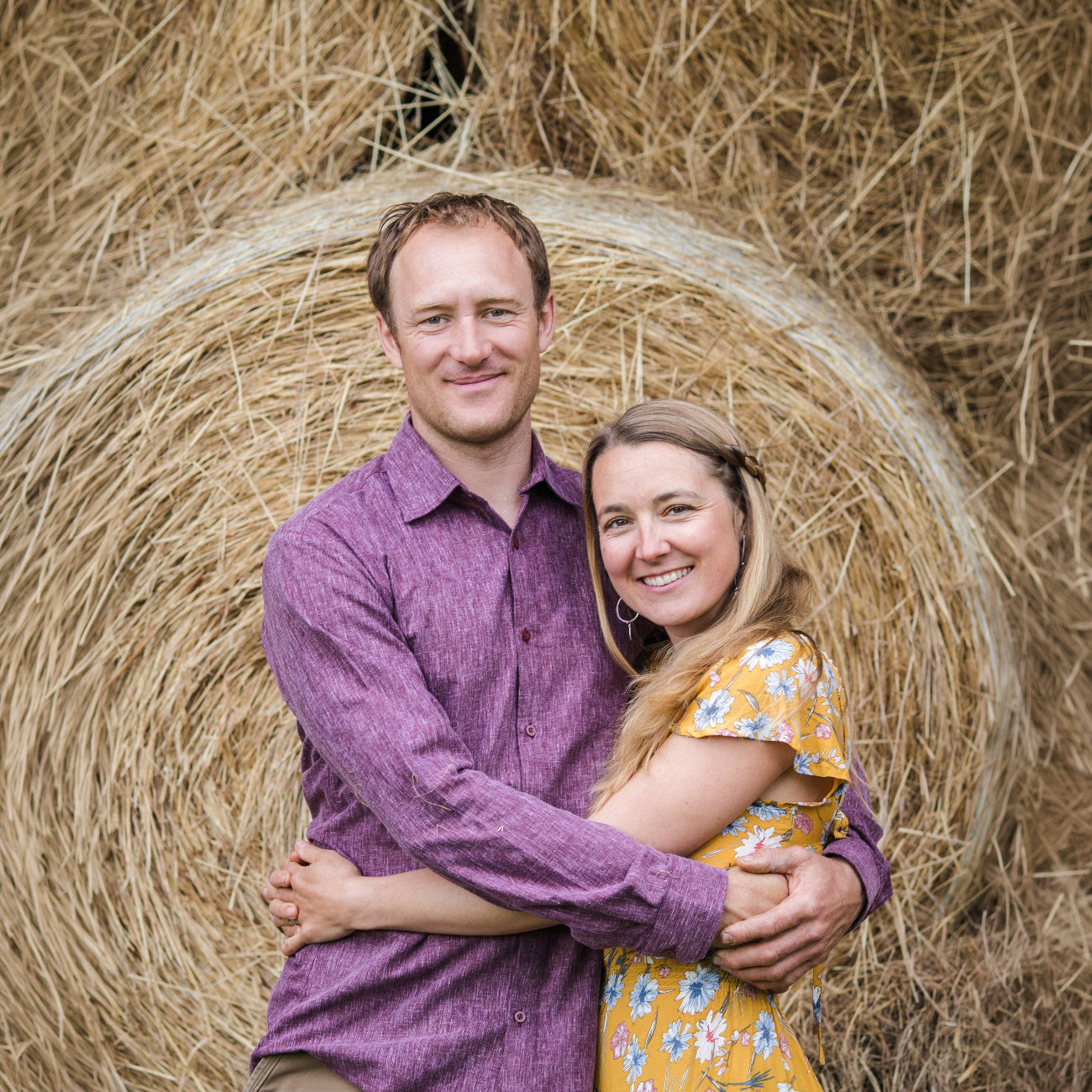 Kilcher Homestead in front of a hay bale on a farm