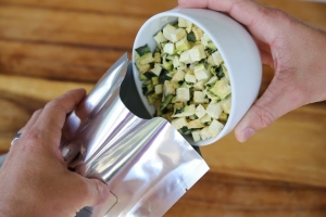 freeze zucchini being poured into a mylar bag