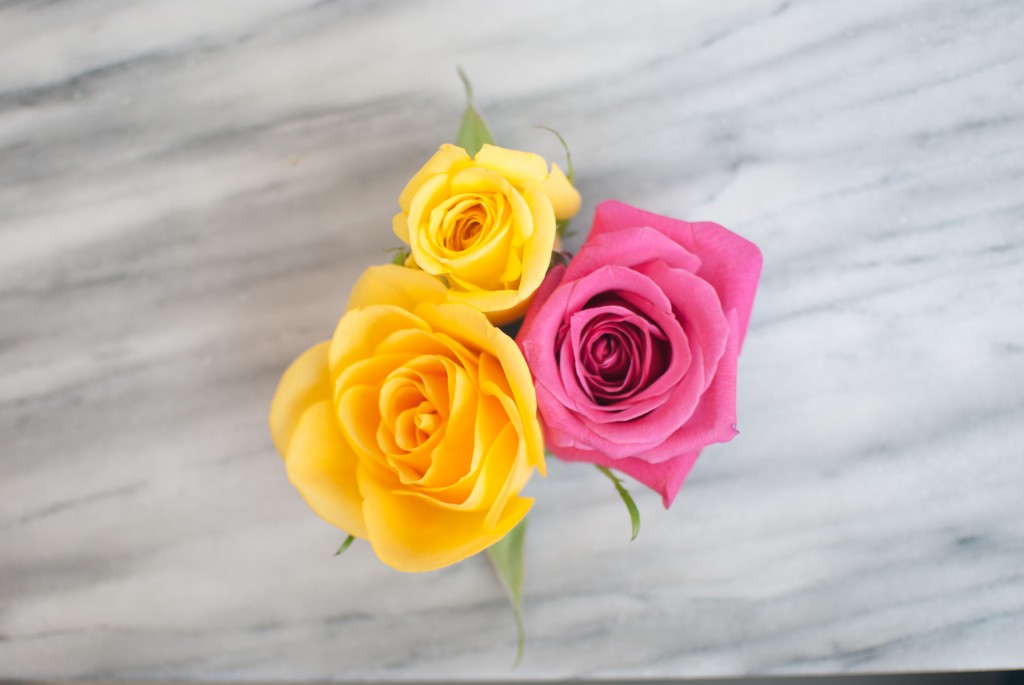 two yellow flowers and one pink flower