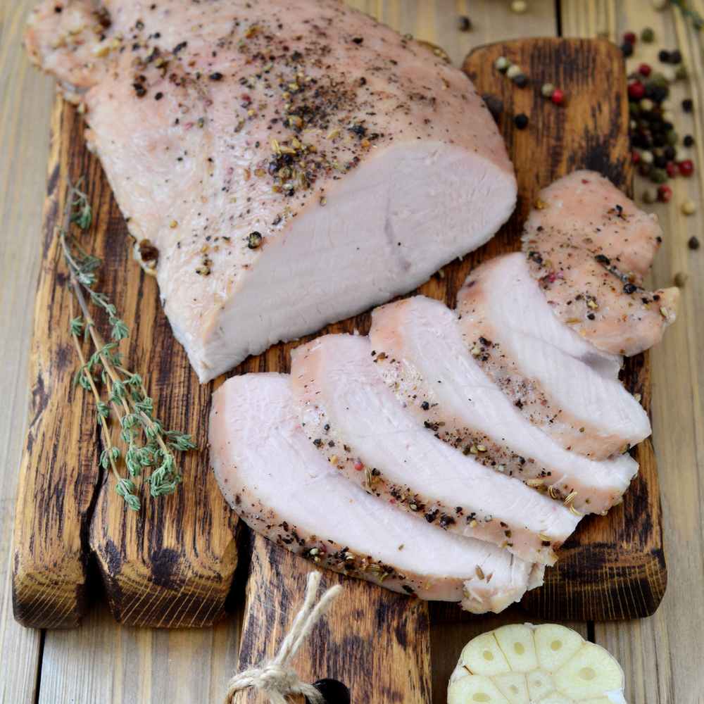 spiced and sliced white meat on a cutting board