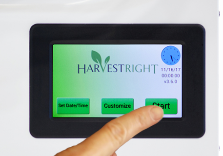 a close up of the Harvest Right control screen with a finger on the start button