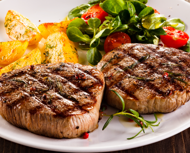 grilled steak, roasted potatoes, and salad with cherry tomatoes