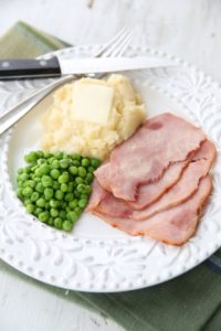 peas, mashed potatoes and ham on a white plate