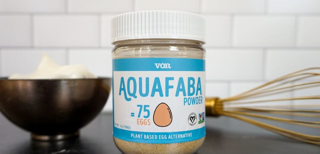 Jar of Aquafaba next to a bowl and a whisk