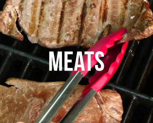 Meats. Steaks on a grill being turned by tongs